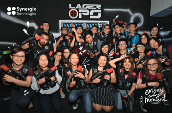 A diverse team of Synergix Technologies employees celebrates together at their LASE Ops event in Singapore.
