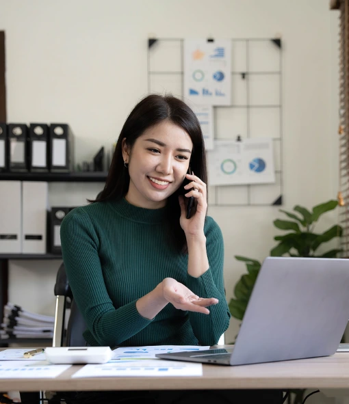 Smiling woman on phone at desk